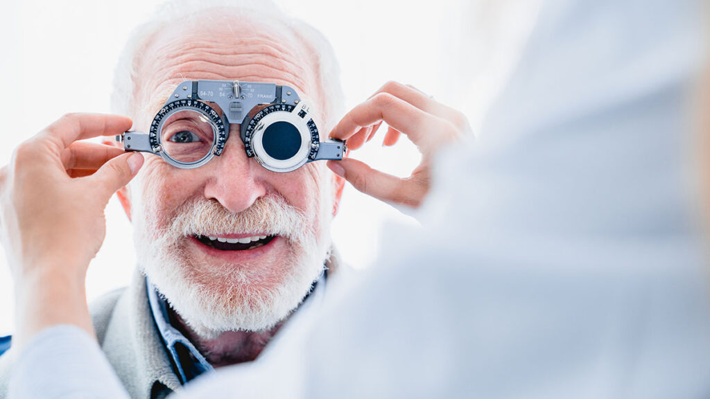 Hombre mayor realizando prueba de graduación con optometrista en Óptica Giner.
